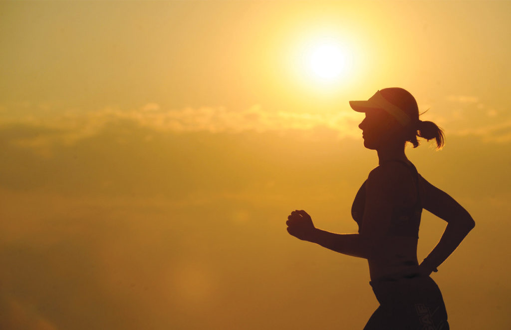 A silhouette of a runner who is reaping the benefits of cannabis on her daily jog.