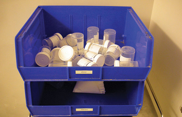 Urine Collection Bottles Sit Empty in a Blue Receptical